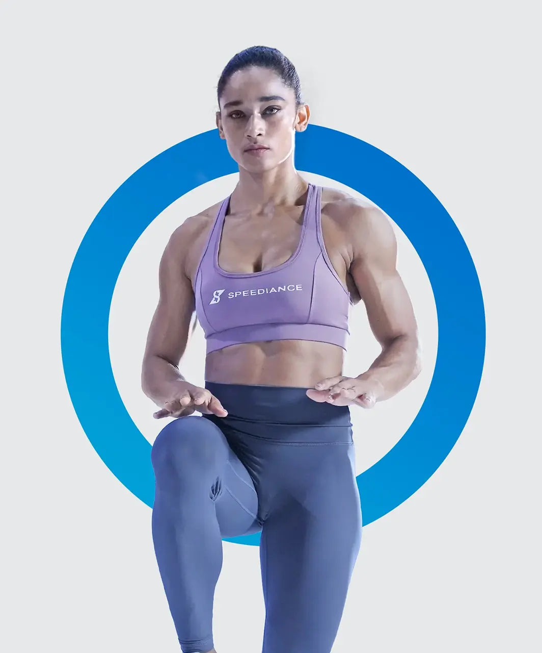 Woman wearing a purple sports bra and leggings with a blue circular design on a light gray background