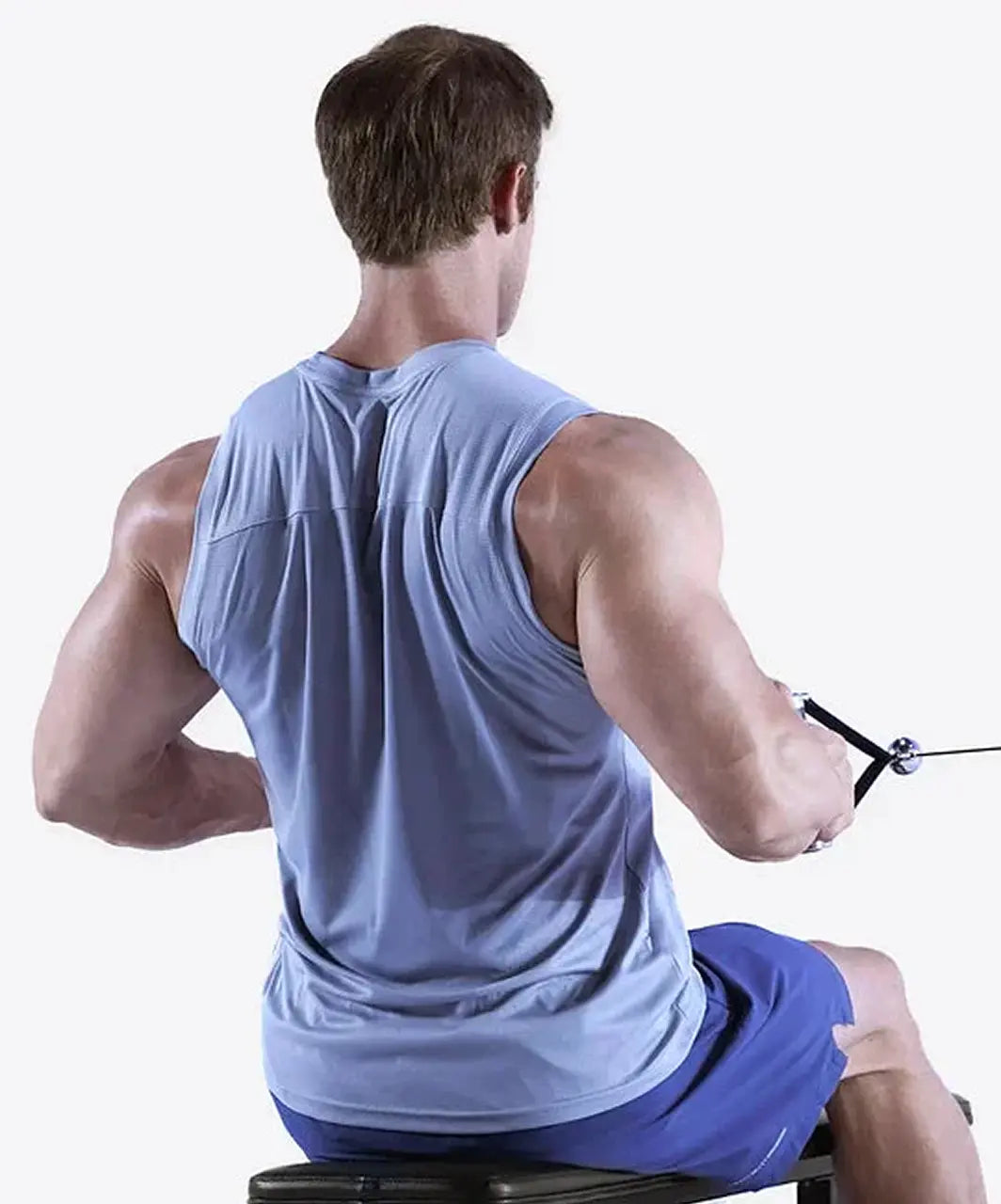 Man exercising on a rowing machine wearing a light blue sleeveless shirt and blue shorts.