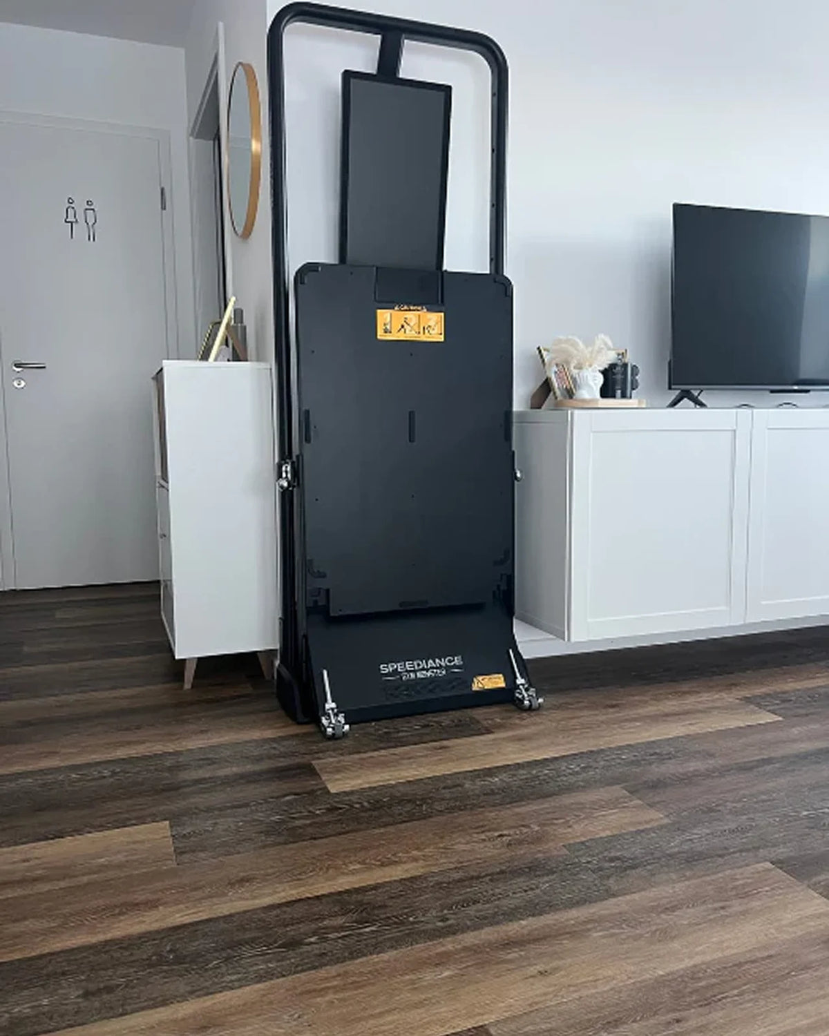Black mobility scooter in a room with a TV and cabinets.
