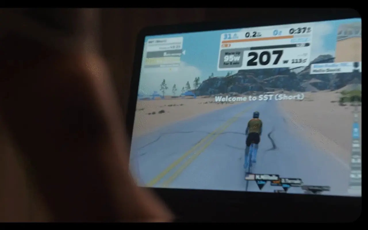 Person playing a cycling simulation game on a screen