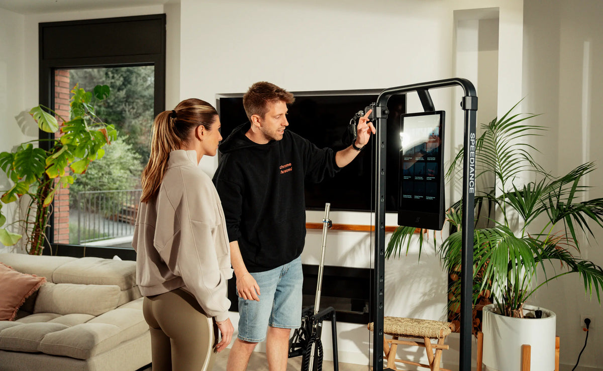 Two people interacting with a large screen in a modern living room.