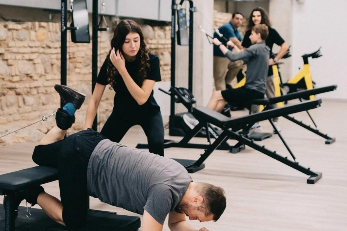 People exercising in a gym setting with various equipment.