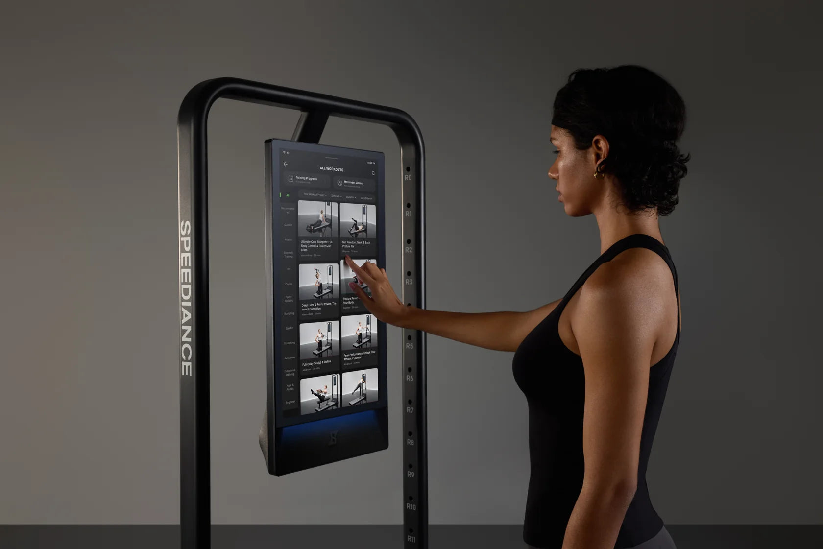 A woman choosing a workout on the actual Gym Monster 3 touchscreen
